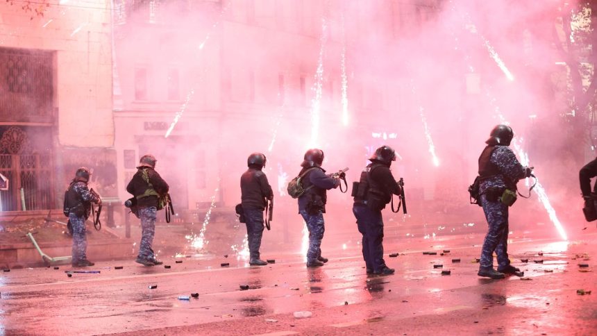 TBILISI, GEORGIA - DECEMBER 02: Protesters set garbage cans on fire and use pyrotechnics against the police while the police uses tear gas as they clash during a protest against the decision to suspend Georgia's EU accession negotiations until 2028 on December 2, 2024 in Tbilisi, Georgia. (Photo by Davit Kachkachishvili/Anadolu via Getty Images)