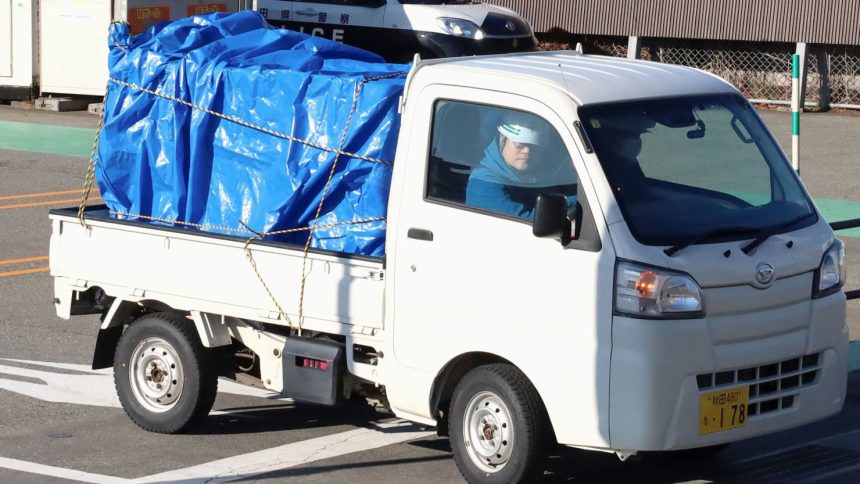 A minitruck carrying a bear which was trapped and killed after a two-day stay in a supermarket is seen leaving the facility in Akita, northeastern Japan, on Dec. 2, 2024. The animal attacked a male employee and ate from the store's meat section, according to police. (Photo by Kyodo News via Getty Images)