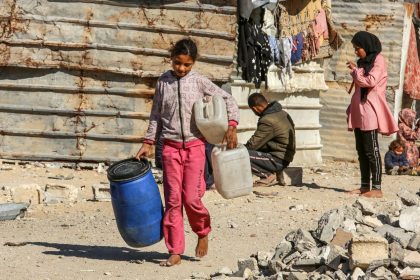 A young girl carries jerry cans in Khan Yunis on December 4.