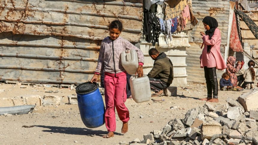 A young girl carries jerry cans in Khan Yunis on December 4.