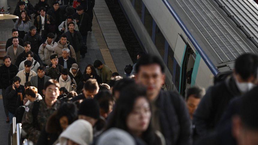 Commuters disembark from a train at a train station in Seoul on December 6, 2024.