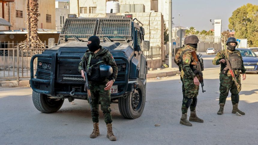 Palestinian security forces stand guard at a roadblock in Jenin following clashes with militants the day before.