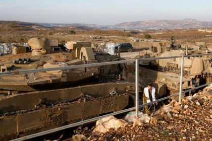 An Israeli soldier walks past tanks deployed near the Israel-Syria border in the Israeli-occupied Golan Heights on December 8, 2024.