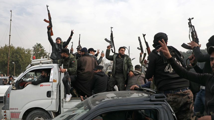 People wave guns in the air as they gather to celebrate the fall of the Syrian regime in Umayyad Square on Sunday in Damascus, Syria.