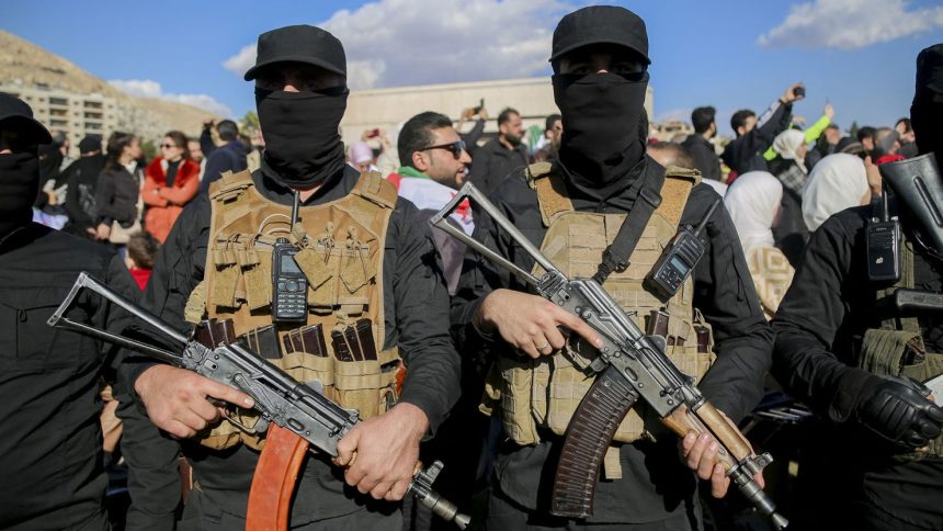 Armed individuals in tactical gear stand amidst a crowd in Damascus, Syria, on December 13.