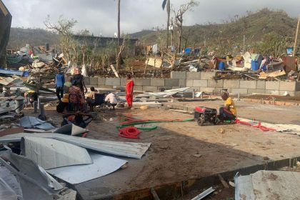 Residents in France's Indian Ocean territory of Mayotte sit among piles of debris of metal sheets and wood on December 15 after homes were destroyed by Cyclone Chido.