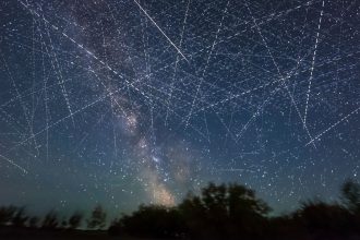 Adding together exposures taken over 30 minutes on an early June night, a composite image depicts the satellite-filled sky.