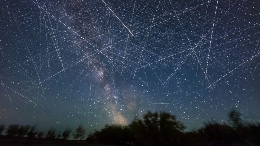 Adding together exposures taken over 30 minutes on an early June night, a composite image depicts the satellite-filled sky.