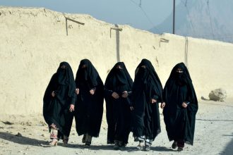 Afghan women walk along a street in Kandahar on December 18, 2024.