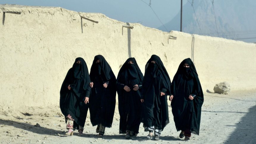 Afghan women walk along a street in Kandahar on December 18, 2024.