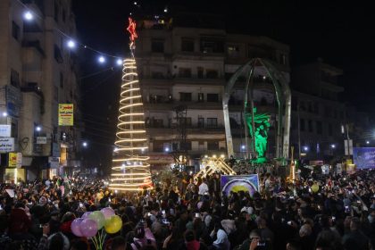 People attend a Christmas tree lighting in the Druze-majority area of Jaramana, in the Damascus countryside, on December 22, 2024.