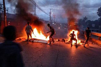 Protesters gather next to a burning barricade in Maputo on December 23, 2024.