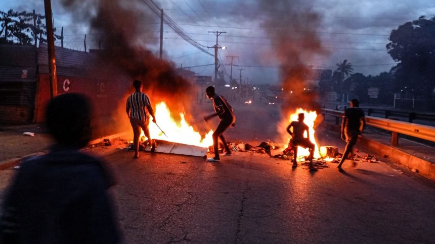 Protesters gather next to a burning barricade in Maputo on December 23, 2024.