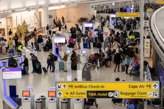 Travelers wait in the JetBlue check-in area at John F. Kennedy International Airport in New York on December 24.