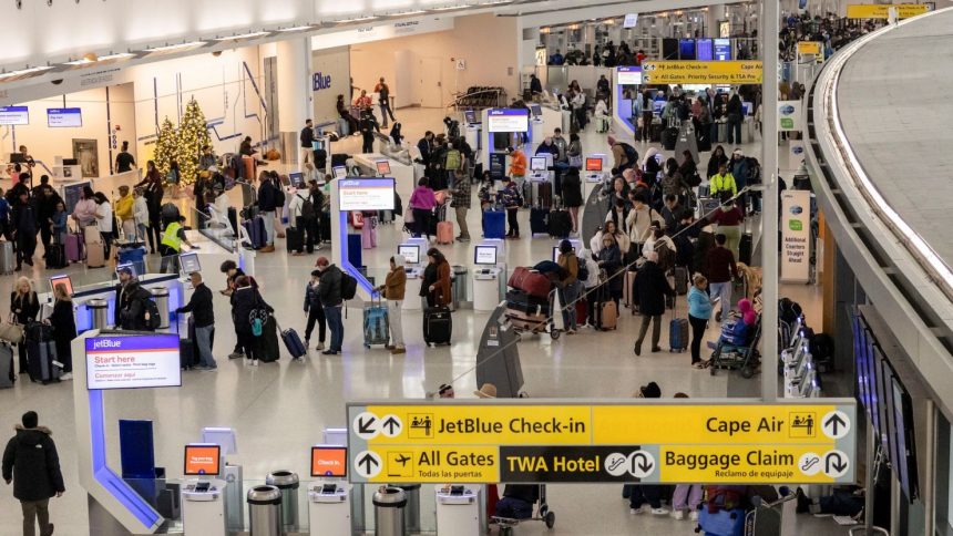 Travelers wait in the JetBlue check-in area at John F. Kennedy International Airport in New York on December 24.