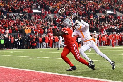 Jeremiah Smith of the Ohio State Buckeyes catches a touchdown pass ahead of Rickey Gibson II of the Tennessee Volunteers during the first quarter at Ohio Stadium.