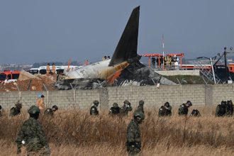 South Korean soldiers search for missing passengers near the wreckage of a Jeju Air Boeing 737-800 aircraft after the plane crashed and burst into flames at Muan International Airport in South Jeolla Province.