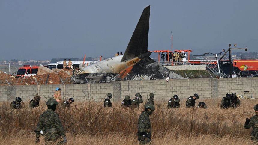 South Korean soldiers search for missing passengers near the wreckage of a Jeju Air Boeing 737-800 aircraft after the plane crashed and burst into flames at Muan International Airport in South Jeolla Province.