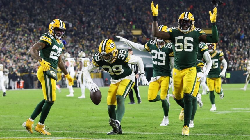 The Packers defense celebrates after an interception by Zayne Anderson.