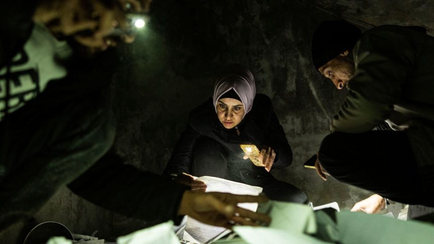 People look through documents at the Saydnaya prison in Damascus on December 11.