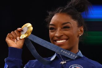 Simone Biles celebrates winning gold at the Paris Games in 2024.