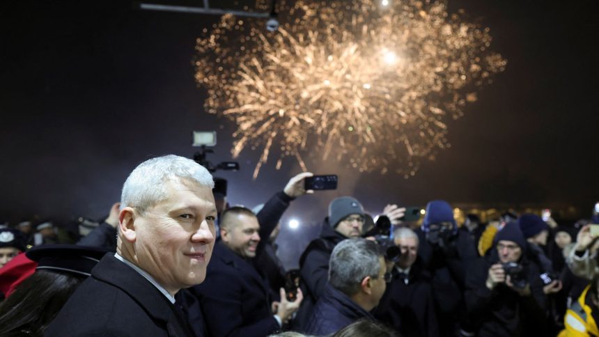 Romanian minister of Internal Affairs Catalin Predoiu amid fireworks as Romania and Bulgaria join the EU's Schengen area.