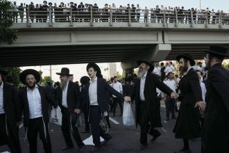 Ultra-Orthodox Jewish men block a highway during a protest against army recruitment in Bnei Brak, Israel, on June 27, 2024.