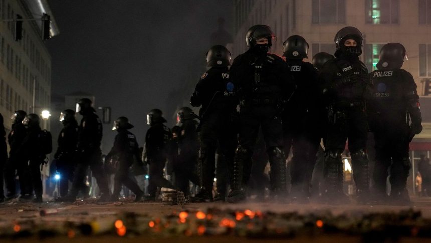 Police officers stand guard in the streets after fireworks celebrations in Berlin, Germany, Wednesday.