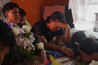 Family and friends mourn over the caskets of brothers Ismael and Josué Arroyo, two of four children who went missing after playing soccer in December, during a wake at the family home in Guayaquil, Ecuador, on January 1.