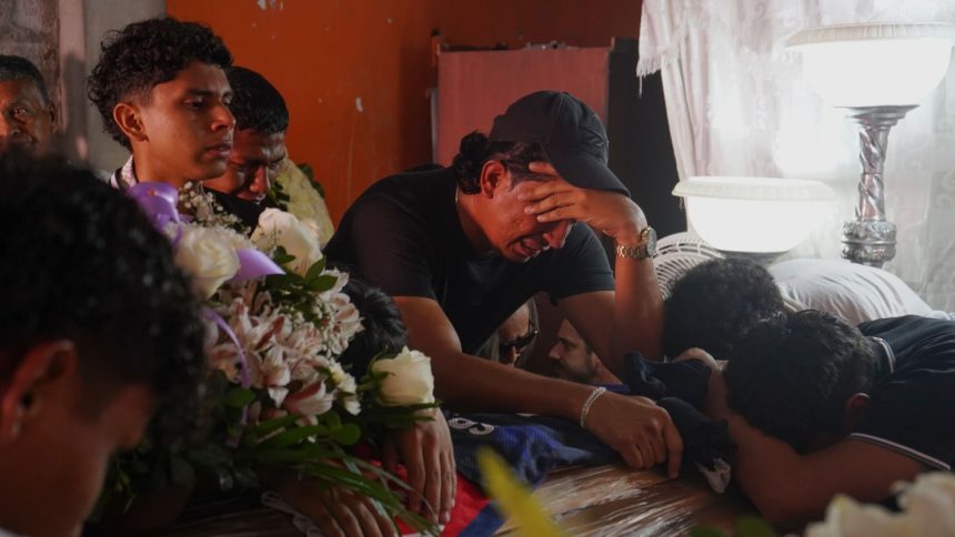 Family and friends mourn over the caskets of brothers Ismael and Josué Arroyo, two of four children who went missing after playing soccer in December, during a wake at the family home in Guayaquil, Ecuador, on January 1.