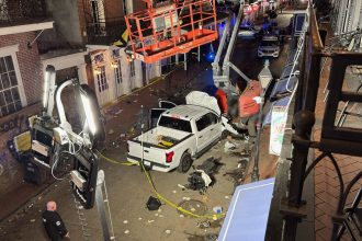 A photo taken from a balcony of the Royal Sonesta New Orleans hotel shows the pickup truck that crashed into a crowd of New Year's Day revelers. Parts of the image have been blurred by CNN.