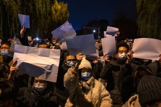 Protesters hold up pieces of white paper to symbolize censorship during a protest against China's strict zero Covid measures in Beijing, China on November 27, 2022.