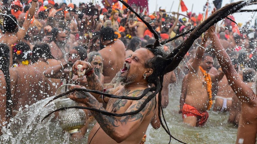 Naga Sadhus take a holy dip in the sacred waters of the Triveni Sangam, the confluence of three holy rivers on the first royal bathing day of the Kumbh Mela on Tuesday, January 14.