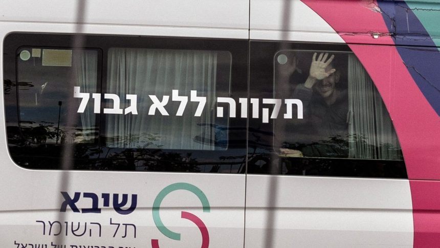 Released hostage Eli Sharabi gestures from behind the window to people who came to show support as he arrived at Sheba Medical Center for treatment on February 8, 2025.