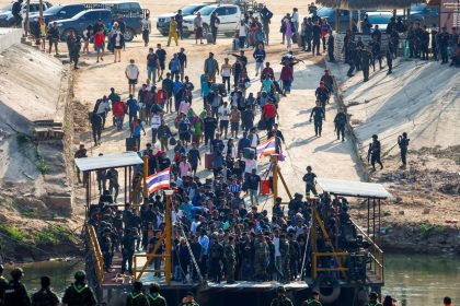 Multinational victims of scam centers, who were tricked or trafficked into working in Myanmar, walk towards a vessel in order to cross Moei River to Thailand, in Phop Phra District, Tak province, Thailand, on February 12, 2025.