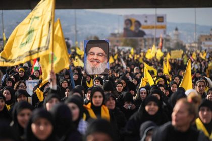 A person holds up a picture of late Hezbollah leader Hassan Nasrallah, who was killed in Israeli airstrikes last year, on the day of a public funeral ceremony in Beirut, Lebanon, on February 23, 2025.