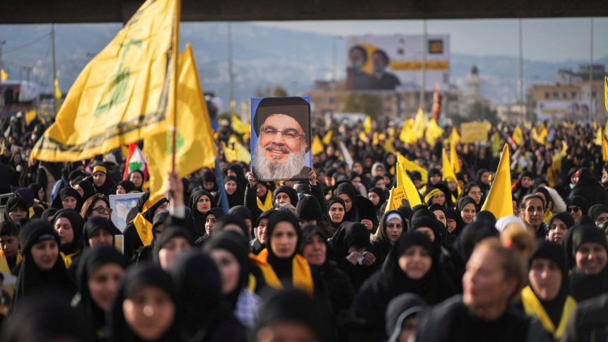 A person holds up a picture of late Hezbollah leader Hassan Nasrallah, who was killed in Israeli airstrikes last year, on the day of a public funeral ceremony in Beirut, Lebanon, on February 23, 2025.