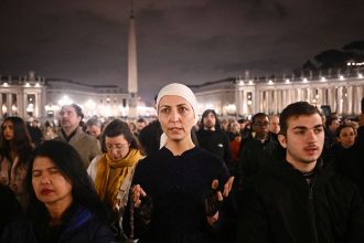 People take part in a prayer service at St. Peter's Square on February 25 2025, as Pope Francis continues his hospitalization.