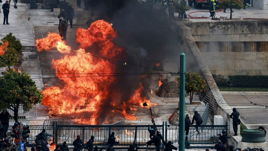 People gather next to fire during clashes, near the Greek parliament at a protest, marking the second anniversary of the country's worst railway disaster in Athens, Greece, February 28, 2025.