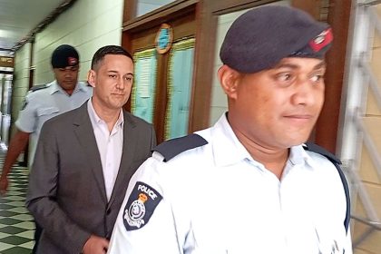 Bradley Robert Dawson, center, is escorted by police at the High Court in Lautoka, Fiji, on Tuesday, Feb. 11, 2025, before being sentenced to at least 18 years in prison for murdering his wife during their honeymoon in Fiji in 2022.