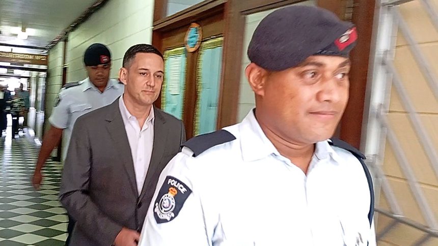 Bradley Robert Dawson, center, is escorted by police at the High Court in Lautoka, Fiji, on Tuesday, Feb. 11, 2025, before being sentenced to at least 18 years in prison for murdering his wife during their honeymoon in Fiji in 2022.