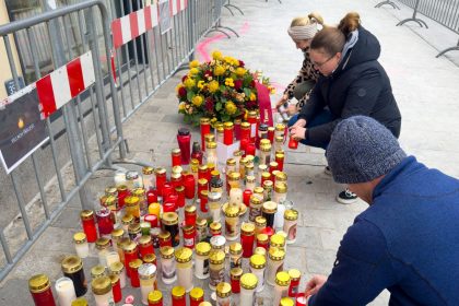 People light candles at the site of the stabbing a day after an attack that left a 14-year-old dead and five others injured, in Villach, Austria, Sunday.