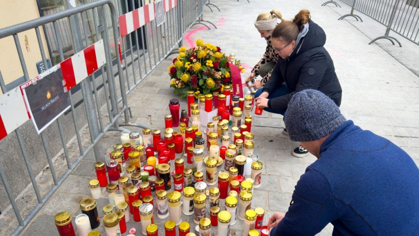 People light candles at the site of the stabbing a day after an attack that left a 14-year-old dead and five others injured, in Villach, Austria, Sunday.