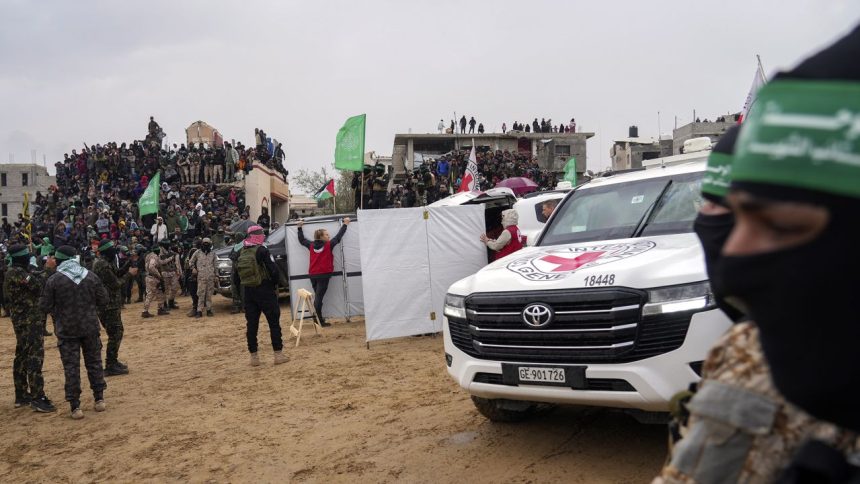 Palestinians gather as Hamas militants hand over coffins containing four bodies to the Red Cross in Khan Younis, southern Gaza Strip, Thursday, Feb. 20, 2025.  Israel has identified three of the bodies as hostages and said the other was of an unknown person. (AP Photo/Abdel Kareem Hana)