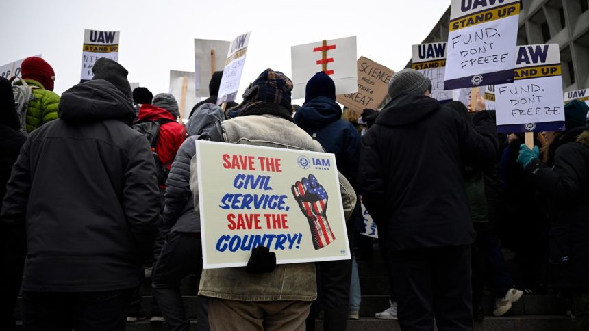 People rally at Health and Human Services headquarters to protest the polices of President Donald Trump and Elon Musk on Wednesday, February 19 in Washington, DC.