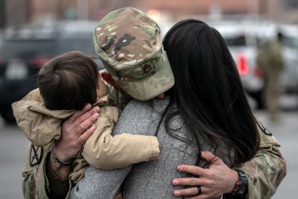 A US Army serviceman embraces his family on December 10, 2020 at Fort Drum, New York.