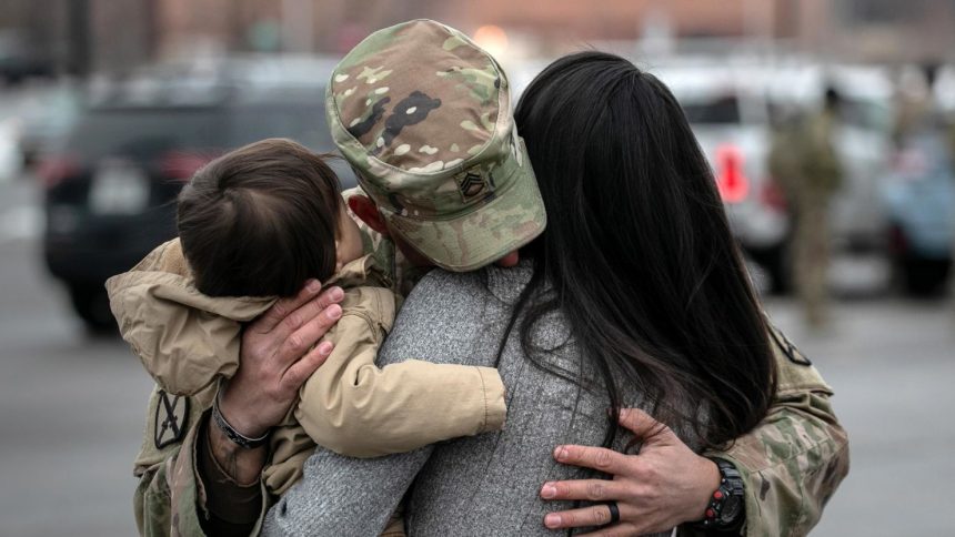 A US Army serviceman embraces his family on December 10, 2020 at Fort Drum, New York.