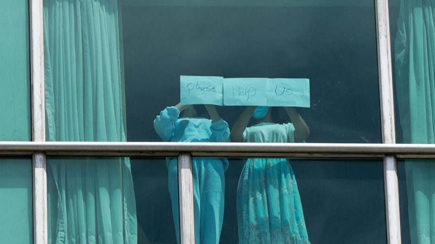 Migrants deported from the US place papers with a written message in the window of the Decapolis Hotel where they are temporarily staying in Panama City on February 18.