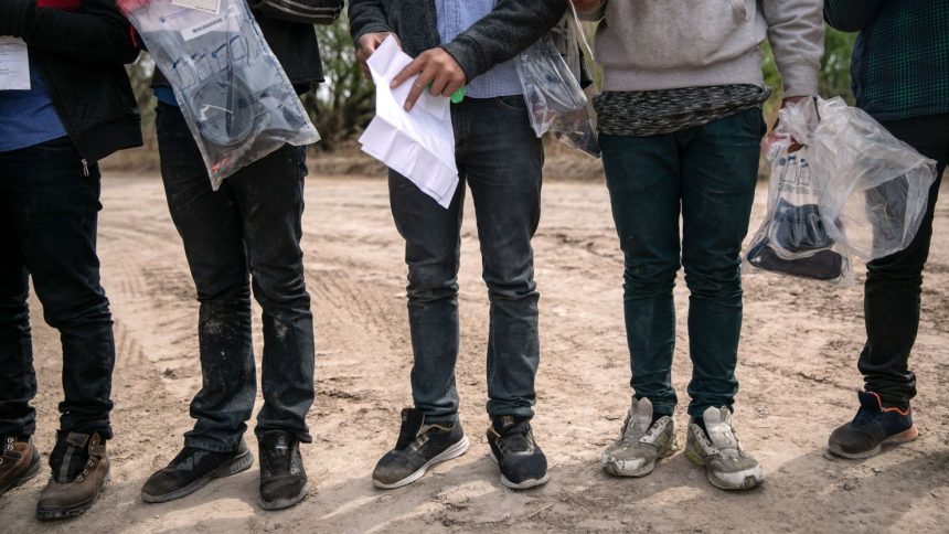 Unaccompanied minors await Border Patrol transport after they crossed the Rio Grande into Hidalgo, Texas, on March 25, 2021.