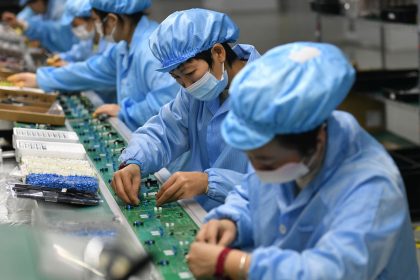 Employees work on a circuit board production line at the workshop of Anhui Shixin Electronic Technology Co LTD in Fuyang, China.